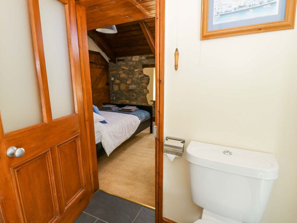 A bathroom with toilet and a glimpse of a bedroom at Parrog Stores Parrog near Newport, Pembrokeshire