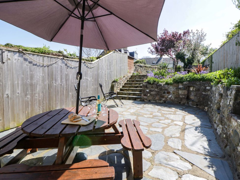 A garden with a table and umbrella at Parrog Stores near Newport, Pembrokeshire