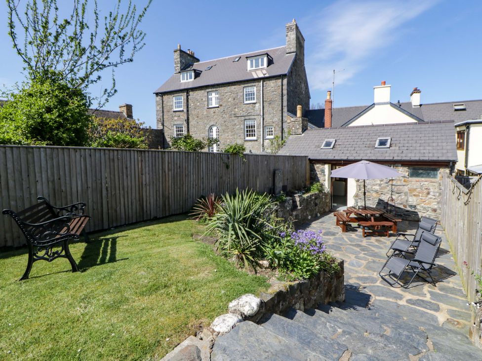 A garden with a bench and dining table at Parrog Stores in Parrog near Newport, Pembrokeshire