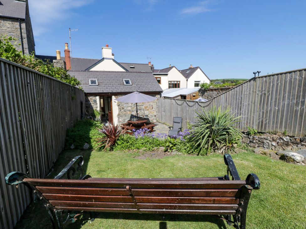 A garden with a wooden bench and parasol at Parrog Stores near Newport, Pembrokeshire