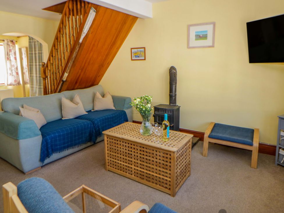 A living room with a sofa and coffee table at Parrog Bach in Parrog near Newport, Pembrokeshire