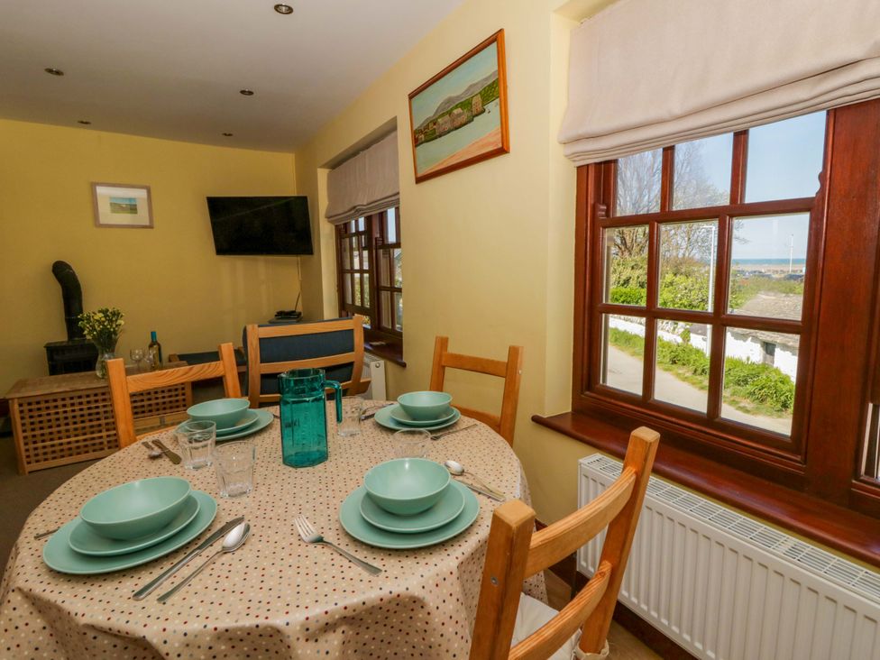 A dining room with a table set for meals at Parrog Bach Parrog near Newport, Pembrokeshire
