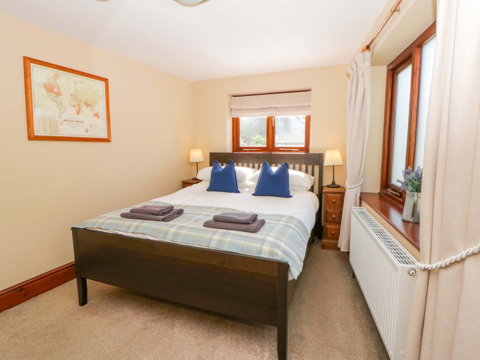 A bedroom with a bed and bedside table at Parrog Bach in Parrog near Newport, Pembrokeshire