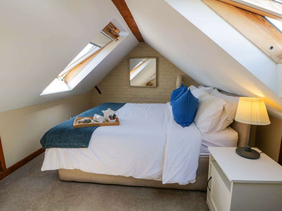 A bedroom with a bed and side table at Parrog Bach near Newport, Pembrokeshire