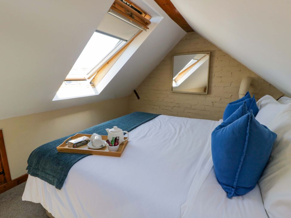 A bedroom with a bed and window at Parrog Bach Parrog near Newport, Pembrokeshire