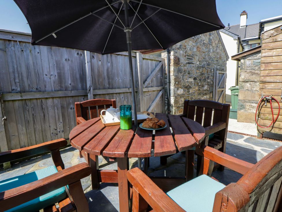 An outdoor seating area with a table and chairs at Parrog Bach in Parrog near Newport, Pembrokeshire