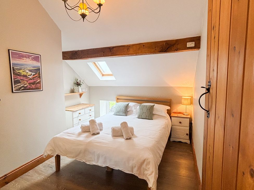 A bedroom with a bed and a drawer at School House Cottage in Newtown near Longnor