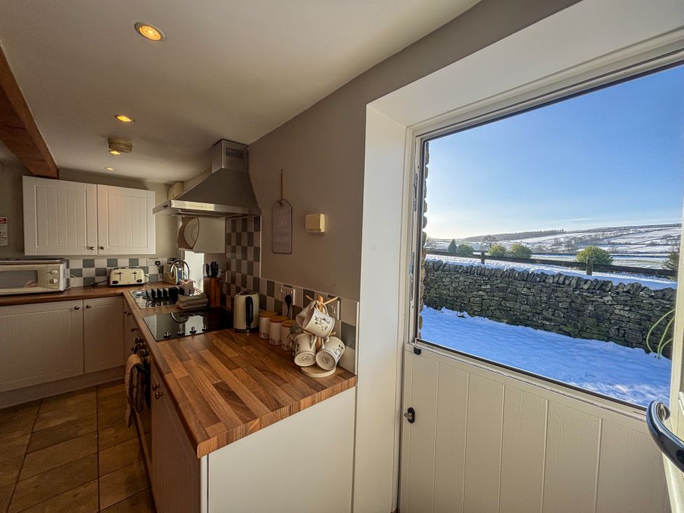 A kitchen with a window view at School House Cottage in Newtown near Longnor