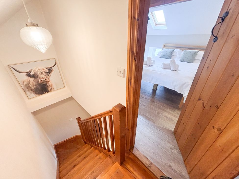 A staircase leading to a bedroom with bed and towels at School House Cottage Newtown near Longnor