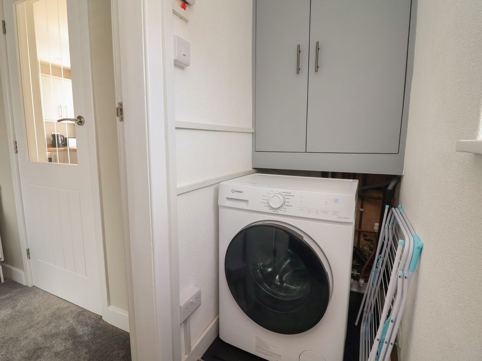 A laundry room with a washing machine and storage cabinet at 7 Grantham Road Southport