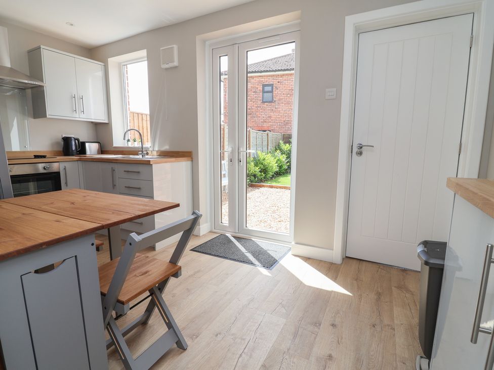 A kitchen with a dining table and door to the garden at 7 Grantham Road Southport