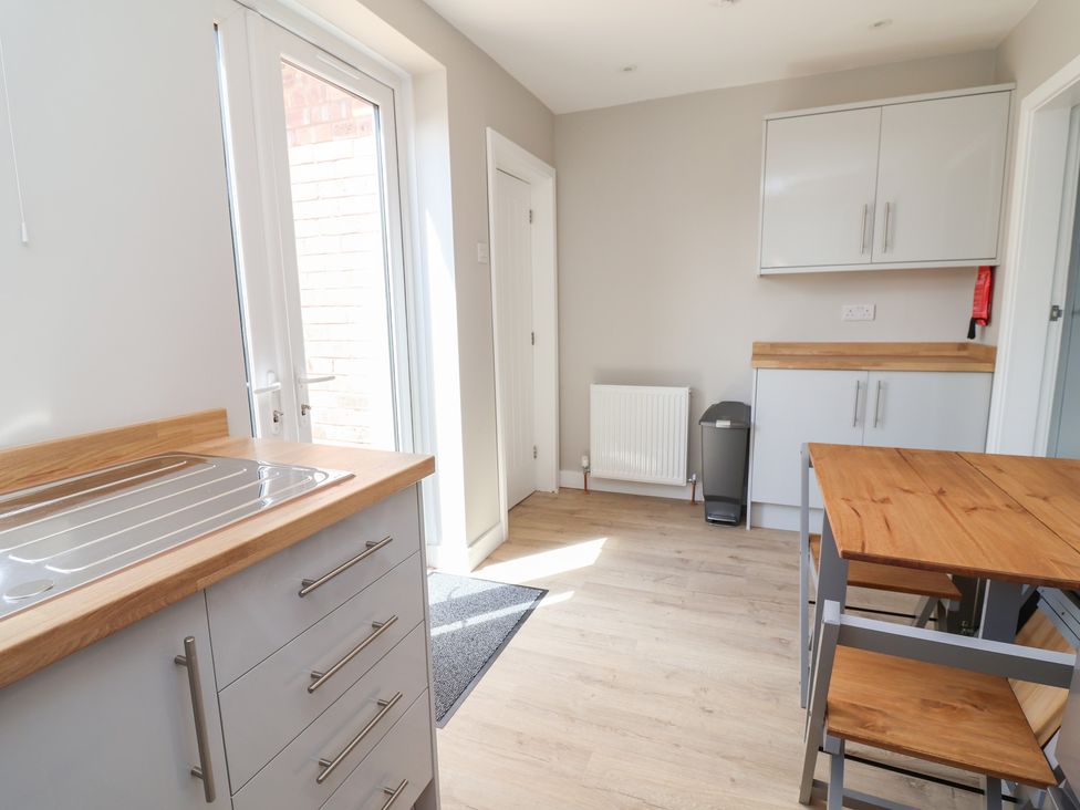 A kitchen with a sink and table at 7 Grantham Road in Southport