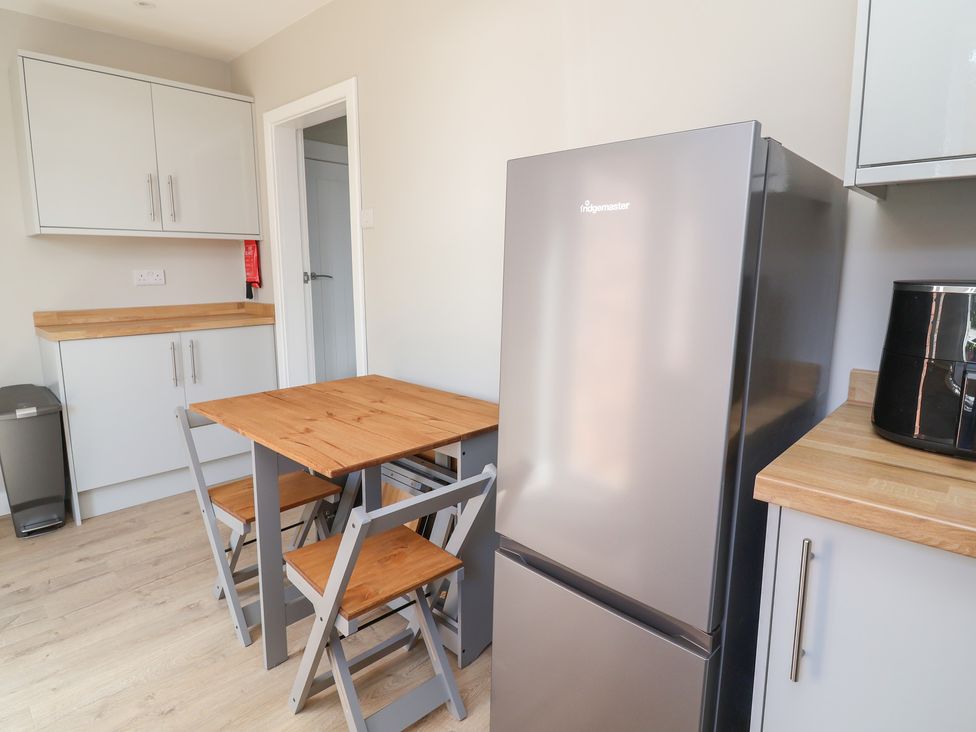A kitchen with a fridge and table at 7 Grantham Road in Southport