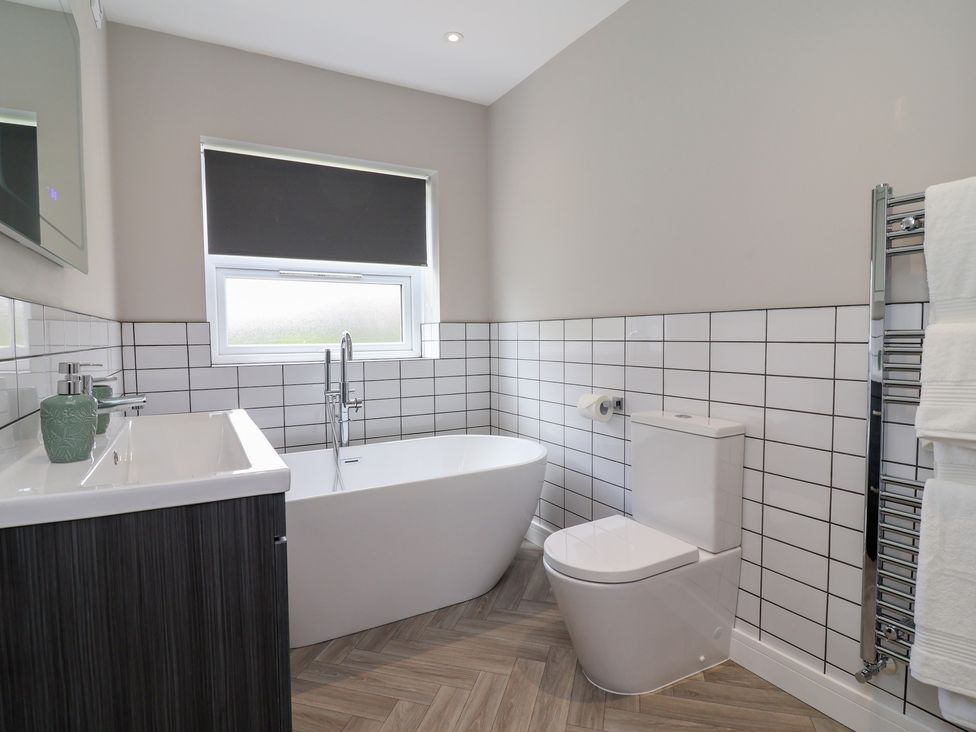 A bathroom with a bath tub and toilet at 7 Grantham Road in Southport