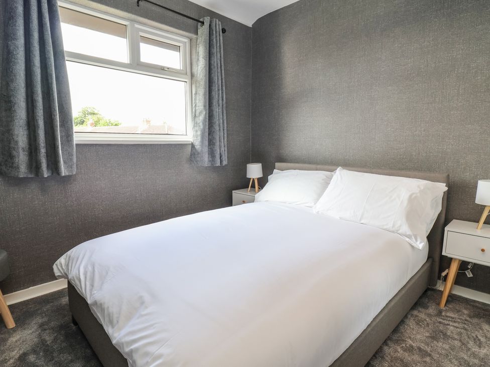 A bedroom with a bed and nightstands at 7 Grantham Road Southport