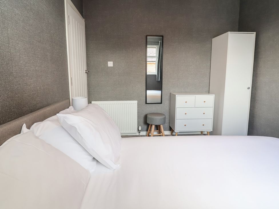 A bedroom with a bed, dresser, and mirror at 7 Grantham Road Southport