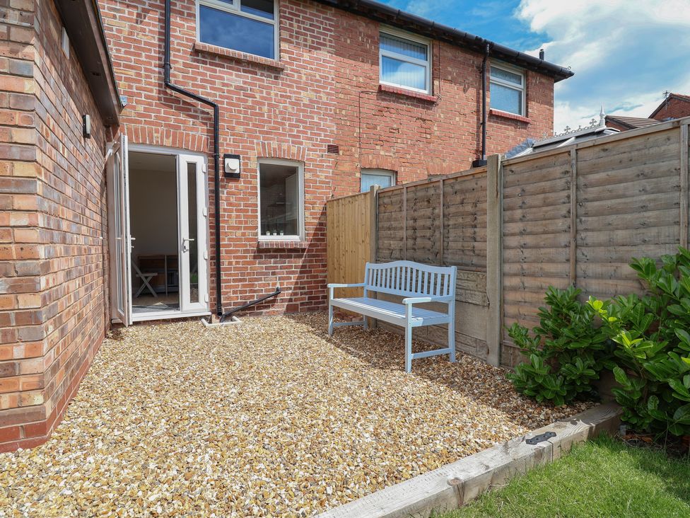 A garden with gravel and a bench at 7 Grantham Road in Southport