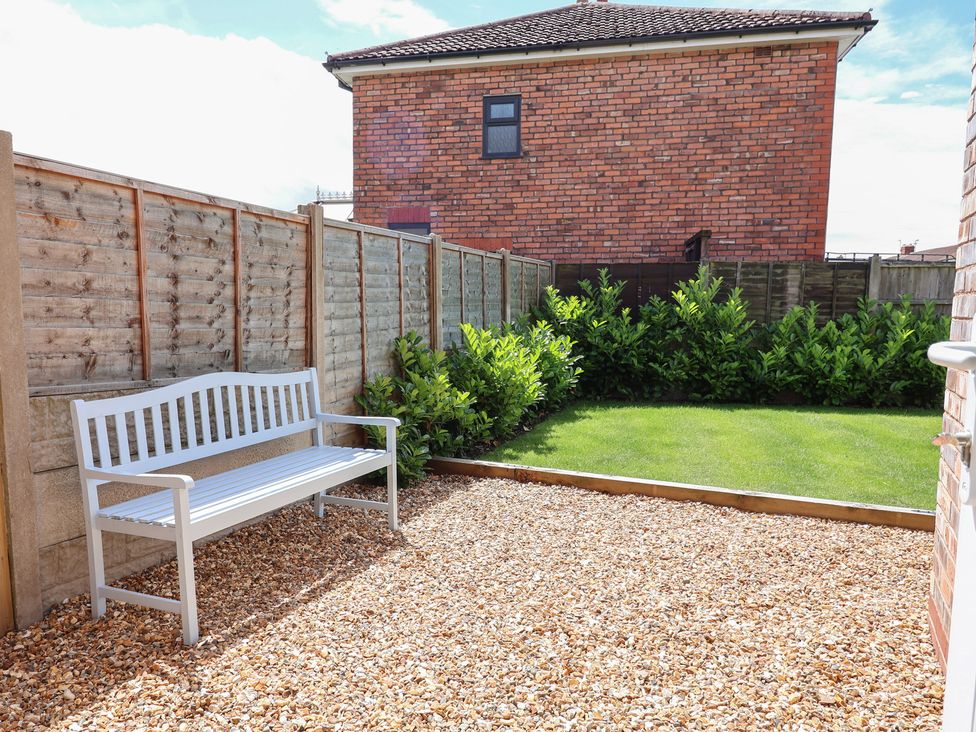 A garden with a bench beside gravel and grass at 7 Grantham Road Southport