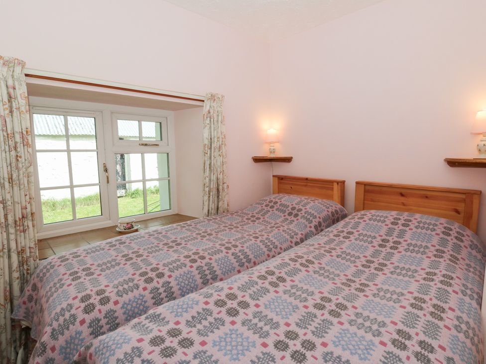 A bedroom with twin beds and a window at Llainorfa in Maenygroes near New Quay