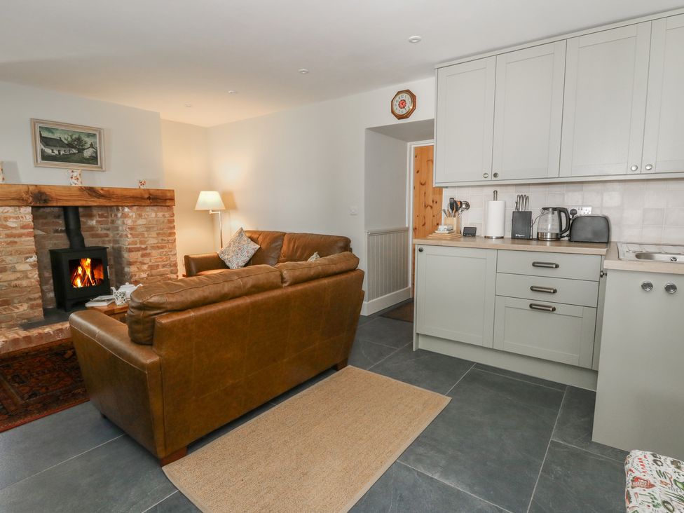 A living room with a sofa and fireplace at Llainorfa in Maenygroes near New Quay