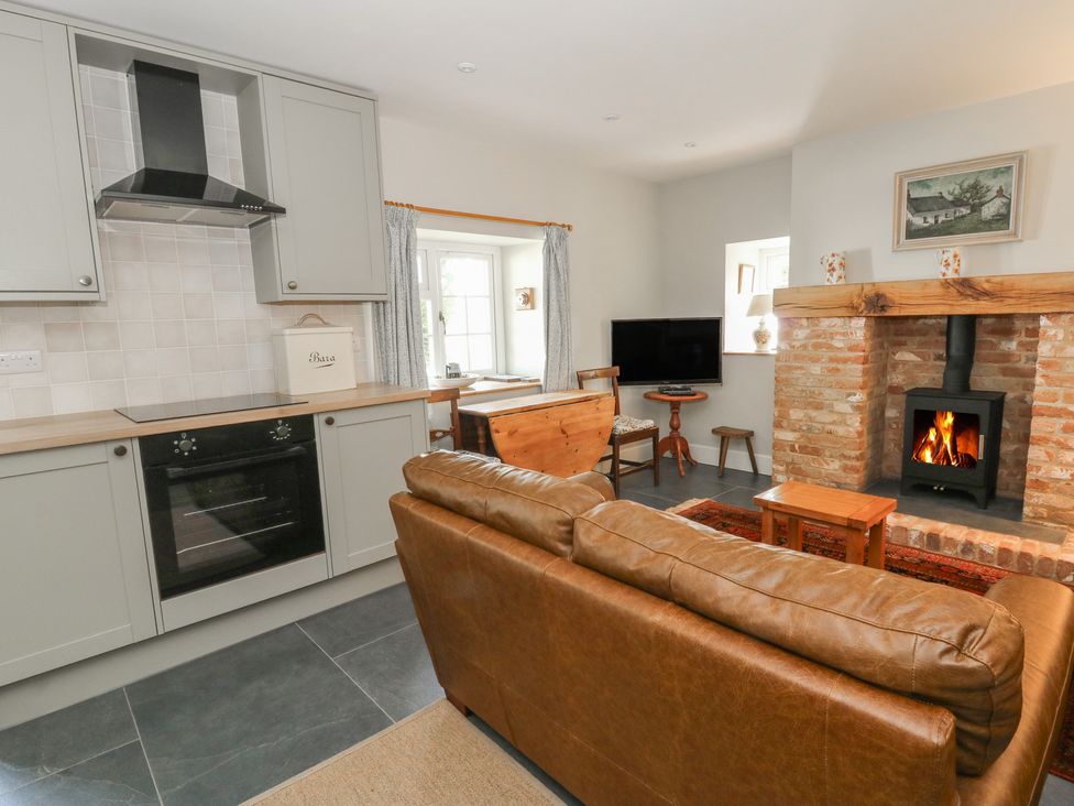 A kitchen with a fireplace and dining area at Llainorfa, Maenygroes near New Quay