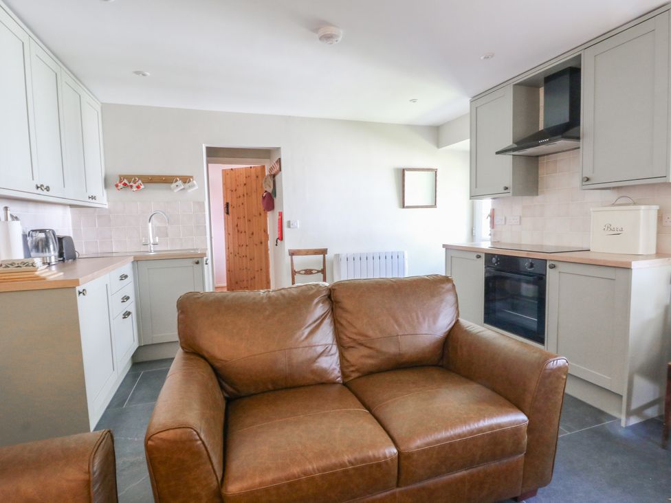 A kitchen with a sofa and appliances at Llainorfa in Maenygroes near New Quay