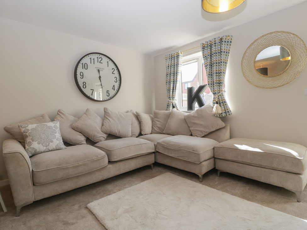 A living room with a sofa and clock at 15 Hey Close Malvern