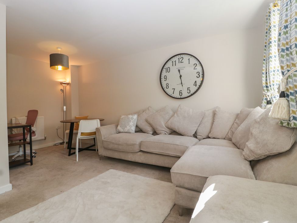 A living room with a sofa and a clock at 15 Hey Close Malvern
