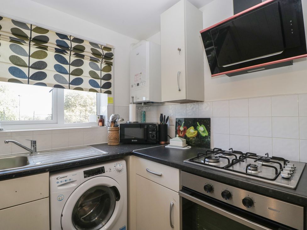 A kitchen with a sink, microwave, washing machine, and stove at 15 Hey Close Malvern