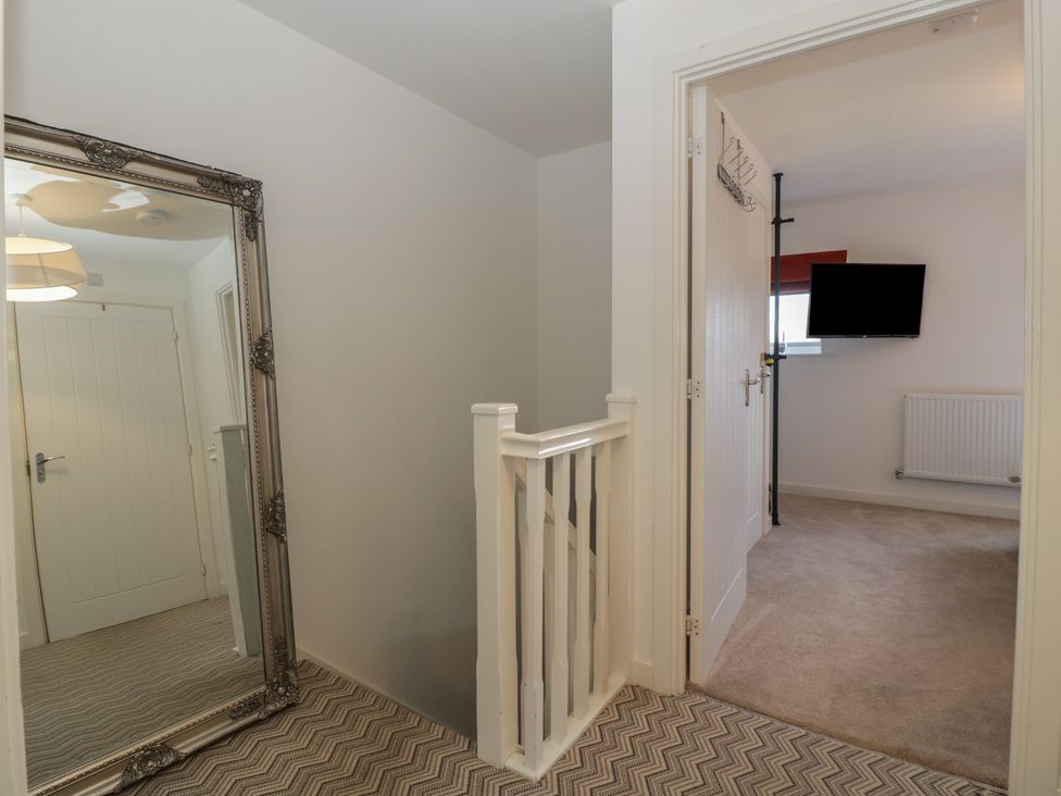 A hallway with a mirror and a television at 15 Hey Close Malvern