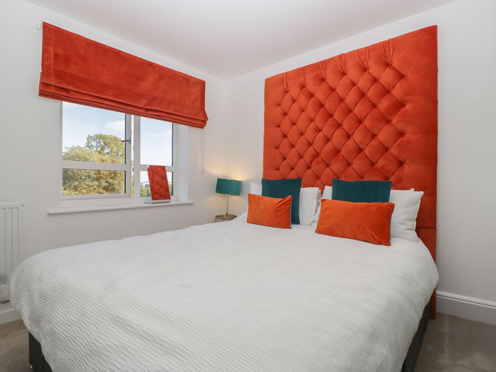 A bedroom with a large bed and decorative headboard at 15 Hey Close Malvern