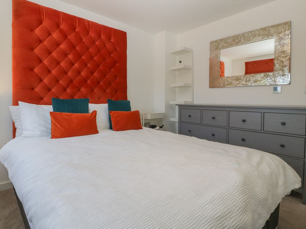 A bedroom with a large bed and a dresser at 15 Hey Close in Malvern