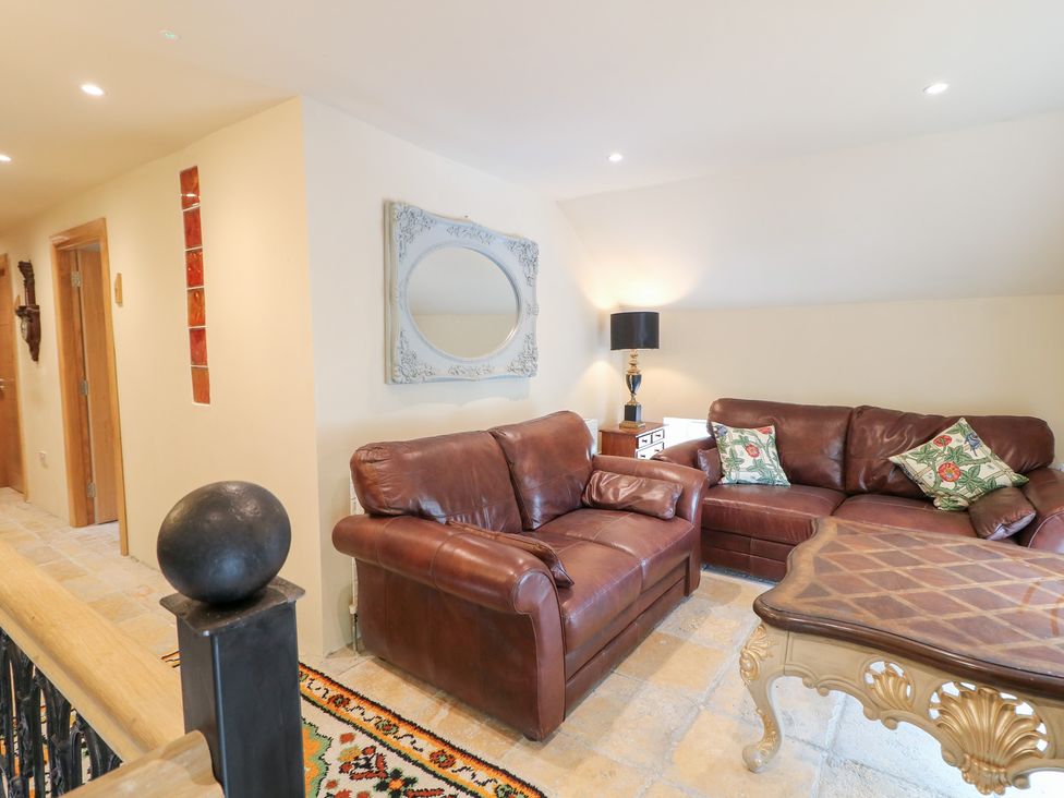 A sitting room with leather sofas and a coffee table at Crea The Mission Hall near Ballymena