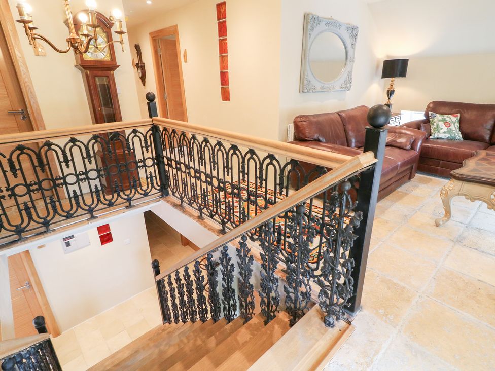 A hallway with staircase and seating area at Crea The Mission Hall near Ballymena