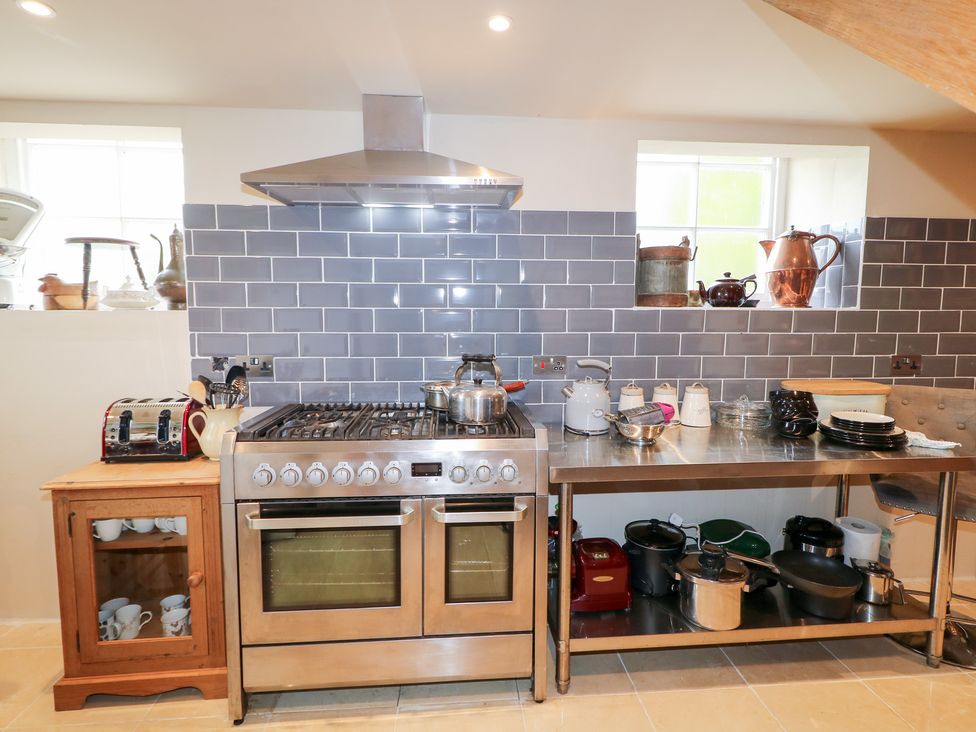A kitchen with a stove and stainless steel table at Crea The Mission Hall near Ballymena