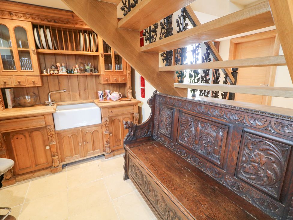 A hallway with a wooden bench and kitchen sink at Crea The Mission Hall near Ballymena
