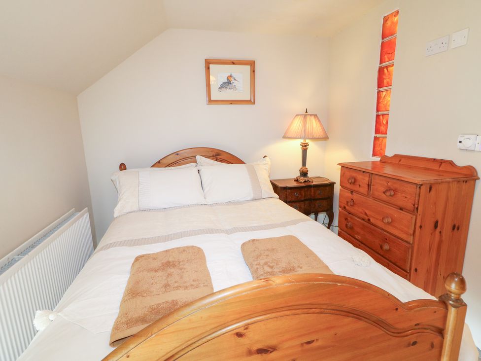 A bedroom with a bed and a nightstand at Crea The Mission Hall near Ballymena