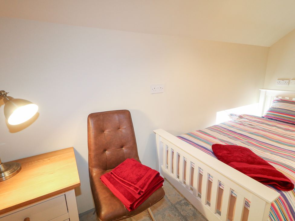 A bedroom with a bed, chair, and lamp at Crea The Mission Hall near Ballymena