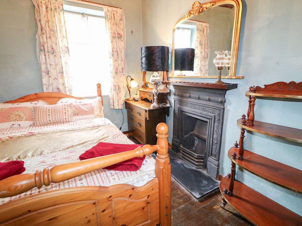 A bedroom with a bed and a fireplace at Crea The Mission Hall near Ballymena