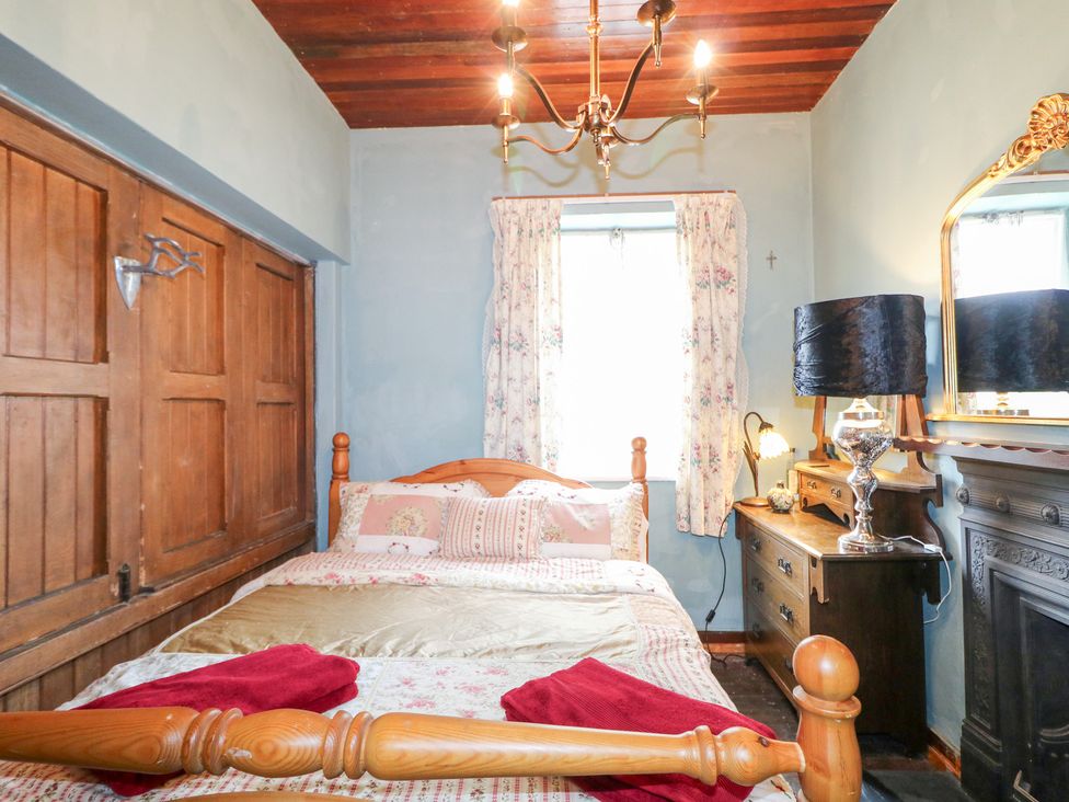 A bedroom with a bed and wooden furniture at Crea The Mission Hall near Ballymena