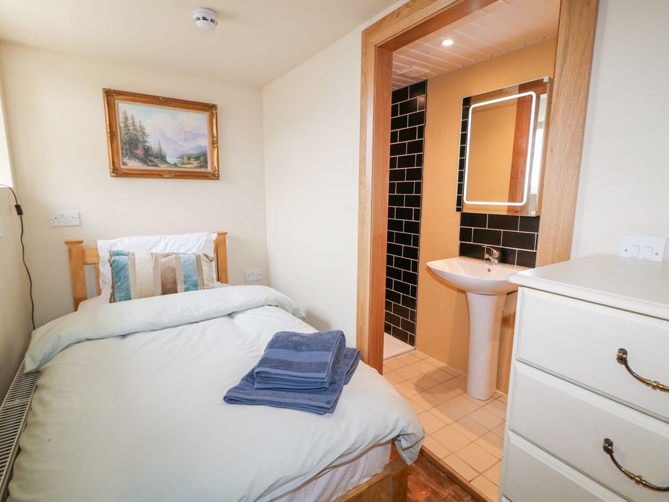 A bedroom with a bed and bathroom area at Crea The Mission Hall near Ballymena
