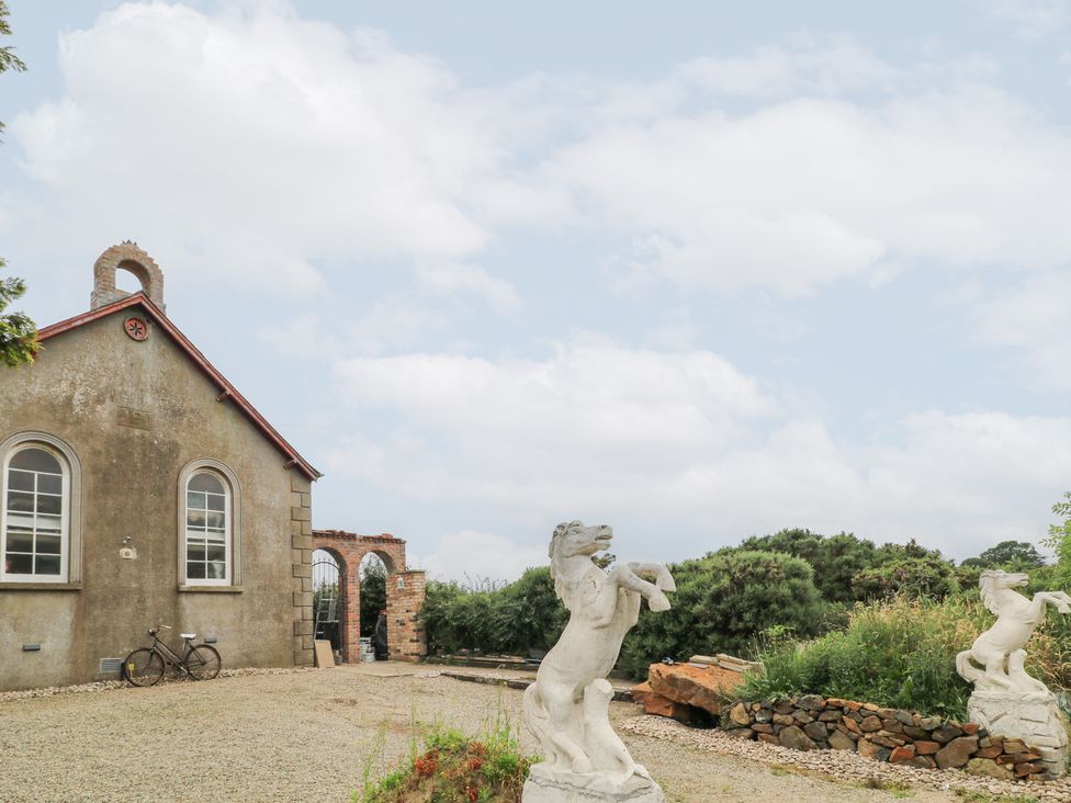 An outdoor scene with a building and statues at Crea The Mission Hall near Ballymena