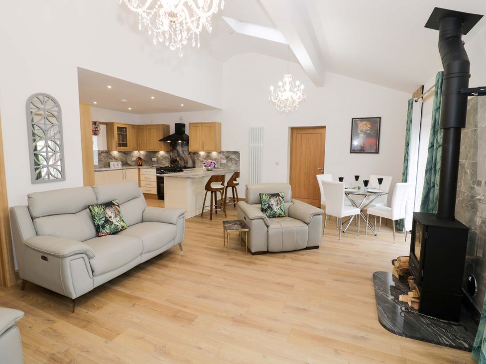 A living room with a sofa and dining area at The Barn in Astwood Bank