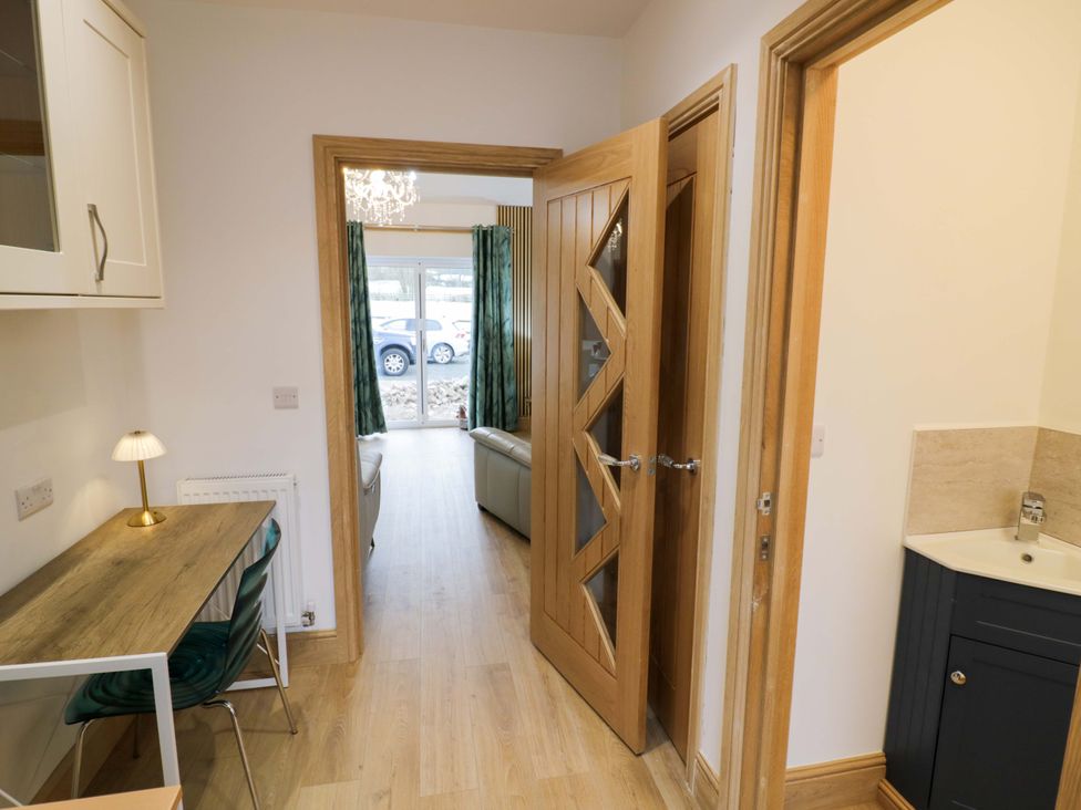 A hallway with a desk and lamp at The Barn in Astwood Bank