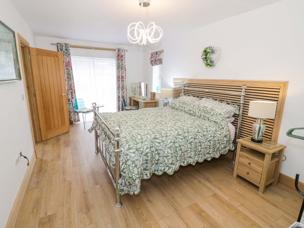 A bedroom with a bed and bedside table at The Barn in Astwood Bank