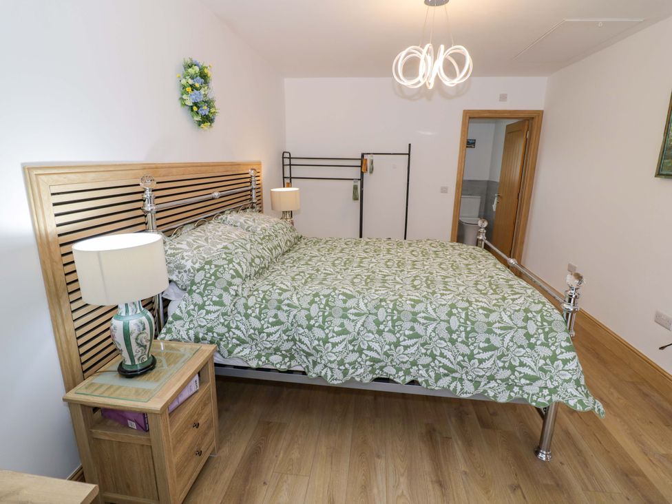 A bedroom with a bed and bedside lamp at The Barn in Astwood Bank