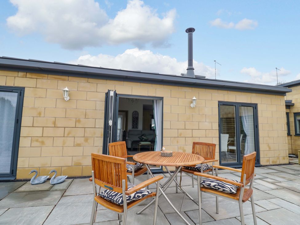 An outdoor patio with a table and chairs at The Barn in Astwood Bank