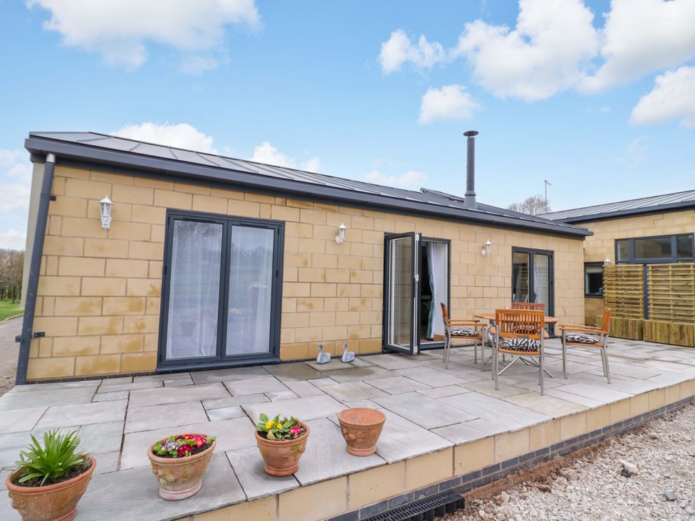 An outdoor seating area with a table and chairs at The Barn in Astwood Bank