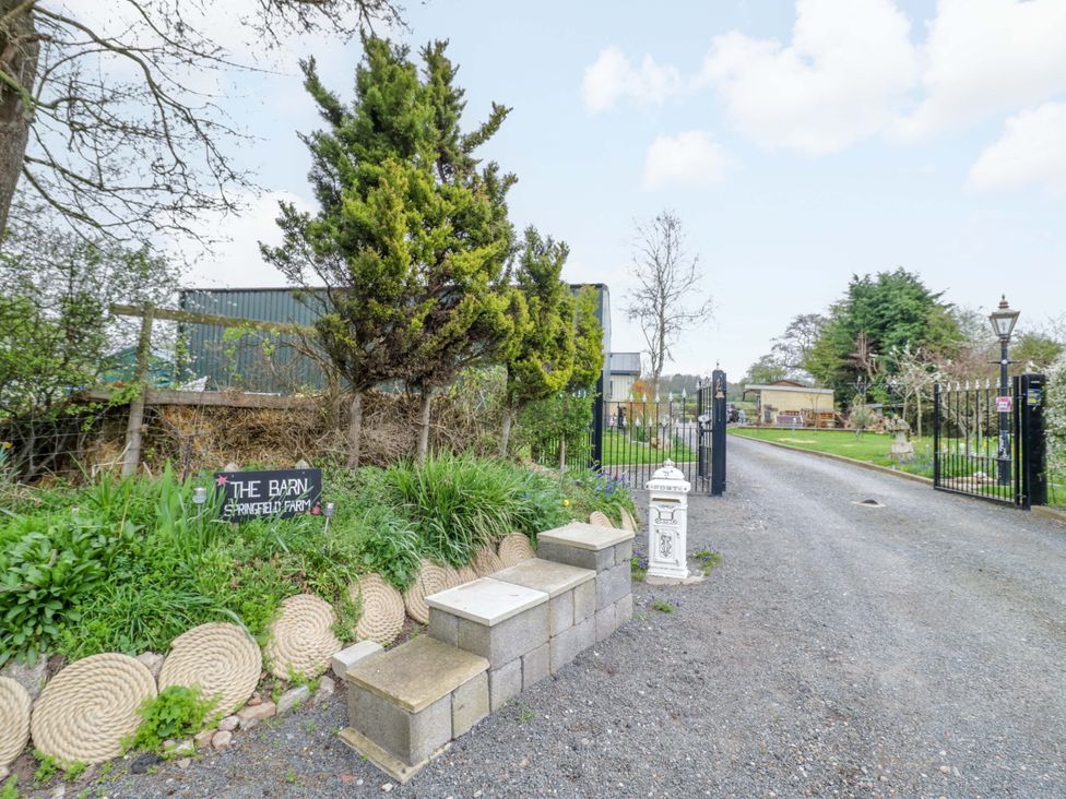 An entrance gate with a sign and plant at The Barn in Astwood Bank