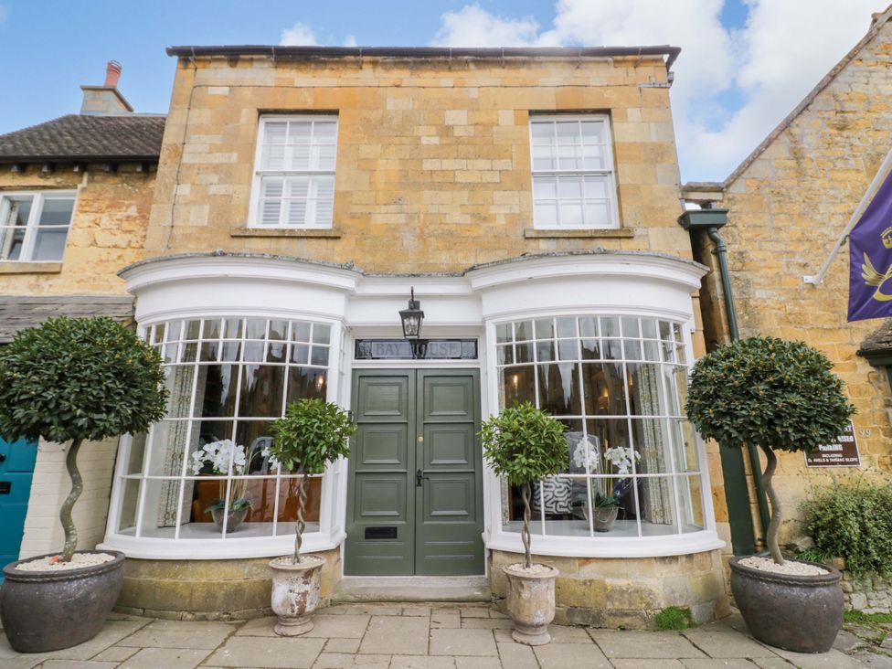 A building exterior with a front door and plants at Bay House Cottage in Broadway
